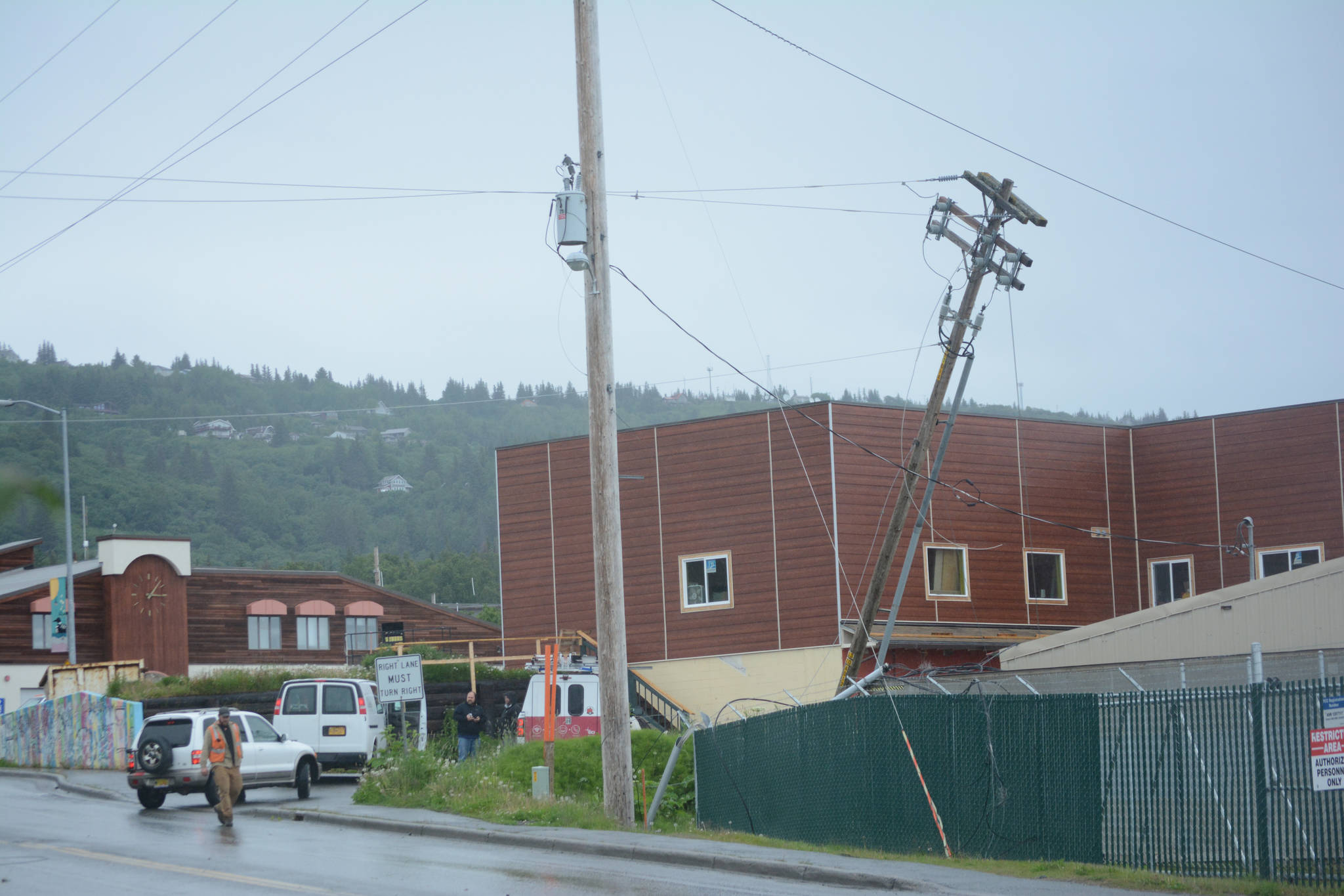 Homer Electric Association crews assess a downed line and pole on Heath Street about 3:15 p.m. Thursday, June 21. An HEA truck snagged a low-hanging telephone line, breaking a pole and bringing down a power line. The outage affected about 430 customers in downtown Homer. No one was injured in the incident. (Photo by Michael Armstrong / Homer News)