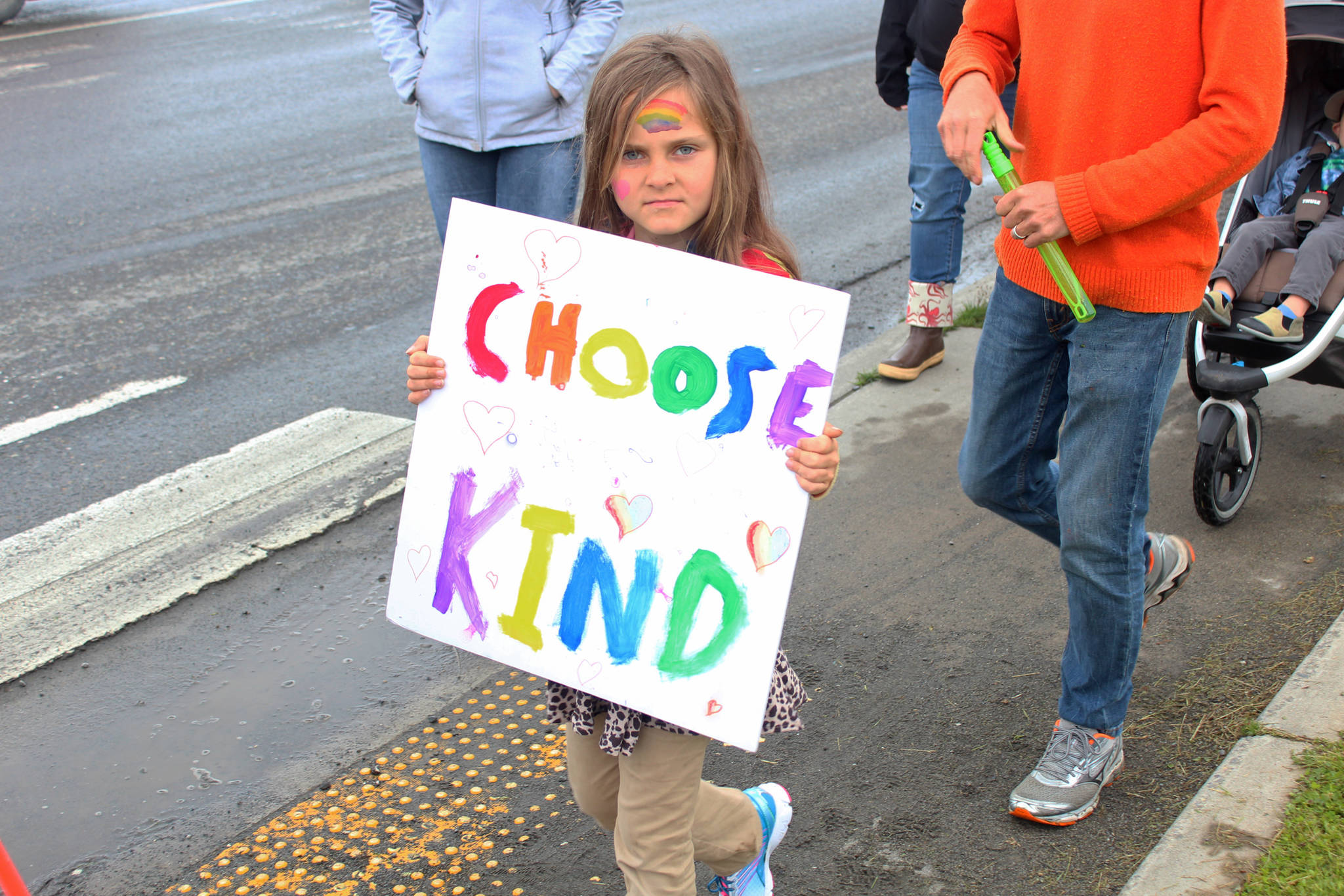 Cate Davis, 8, marches down Pioneer Avenue with sign that reads “Choose kind,” on Saturday, June 23, 2018 during Homer’s first ever Pride March in Homer, Alaska. Davis’ fathers were some of the organizers of the March. (Photo by Megan Pacer/Homer News)