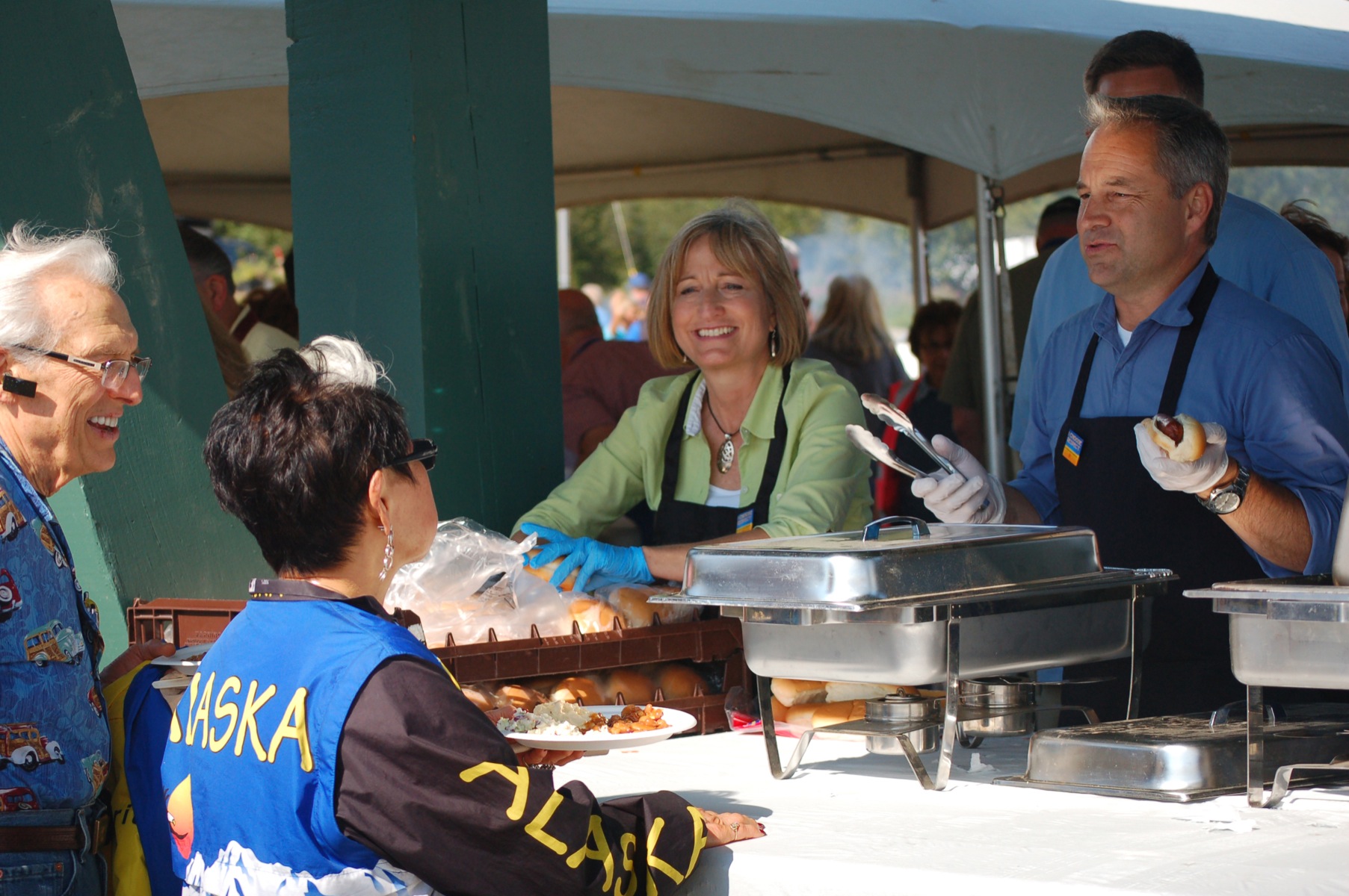 First Lady Sandy Parnell, left, and Gov. Sean Parnell, right, serve food to Thomas and Joanne Munger at the Governor's Picnic in July.-Photo by Michael Armstrong, Homer News