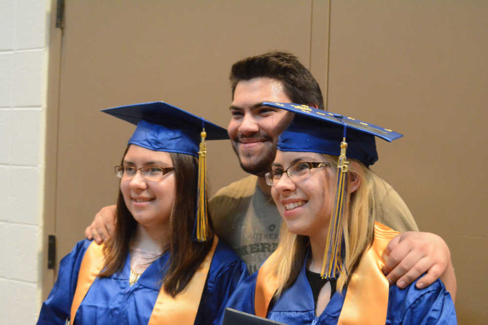 Patrick Lind poses with his sisters, Marissa, left, and Chelsea, right. The twins both graduated from Homer High School on Tuesday.