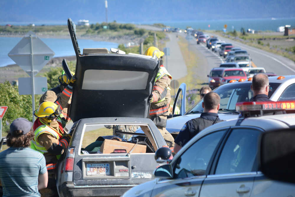 Firefighters peel back the roof of a Toyota sedan as they work to extricate Trevor Fenix, 17,  after he was trapped in the car following a crash about 5 p.m. last Wednesday, June 8, on the Homer Spit at Kachemak Drive.