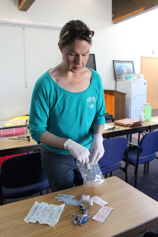 Dr. Sarah Spencer of South Peninsula Hospital refills a safer injection kit, which includes supplies for sterile injection of intraveneous drugs such as syringes, disposable cookers, sterile water, alcochol pads and bandages.