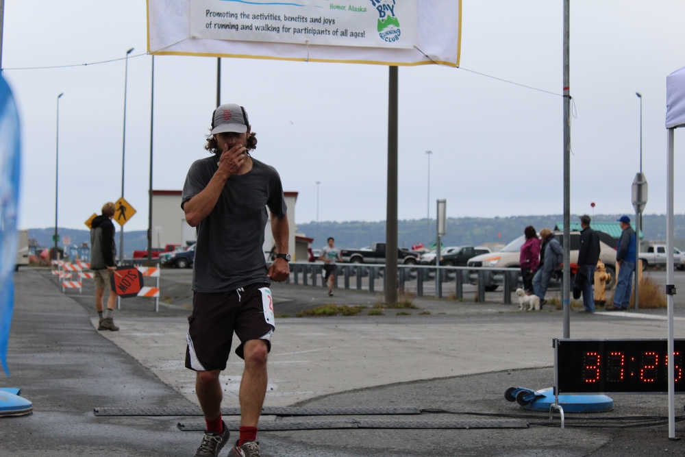 Homer resident Marlin Schuster, 31, crosses the finish line of the Spit Run in third place with a time of 0:37:24.56.