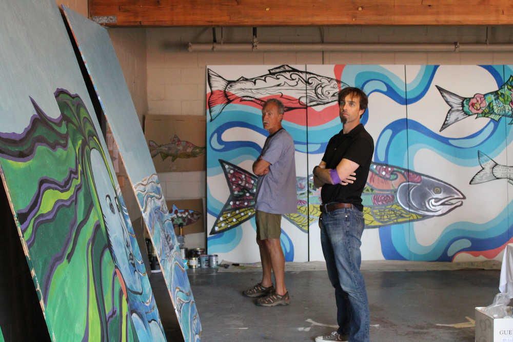 (left to right) Craig Matkin and Bill Jirsa gaze at the Cook Inletkeeper sponsored mural that will be placed in front of the dilapidated building between Bay Realty and Captain's Coffee on Pioneer Avenue. The salmon-filled mural leaning on the back wall is sponsored by Ulmer's Drug and Hardware.