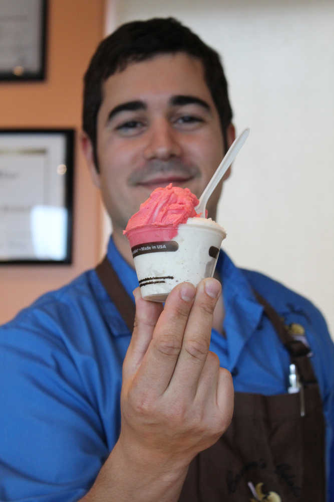 Carmen Ricciardi holds out a freshly scooped cup of Tahitian vanilla bean gelato and raspberry sorbetto in his shop Carmen's Gelato.