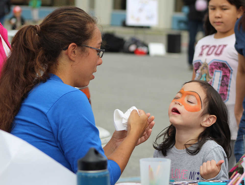 Alexandra Jones, 6, closes her eyes as Aleta Phelps works on a face painting design at the South Peninsula Hospital 60th Anniversary Party on Saturday, July 9.