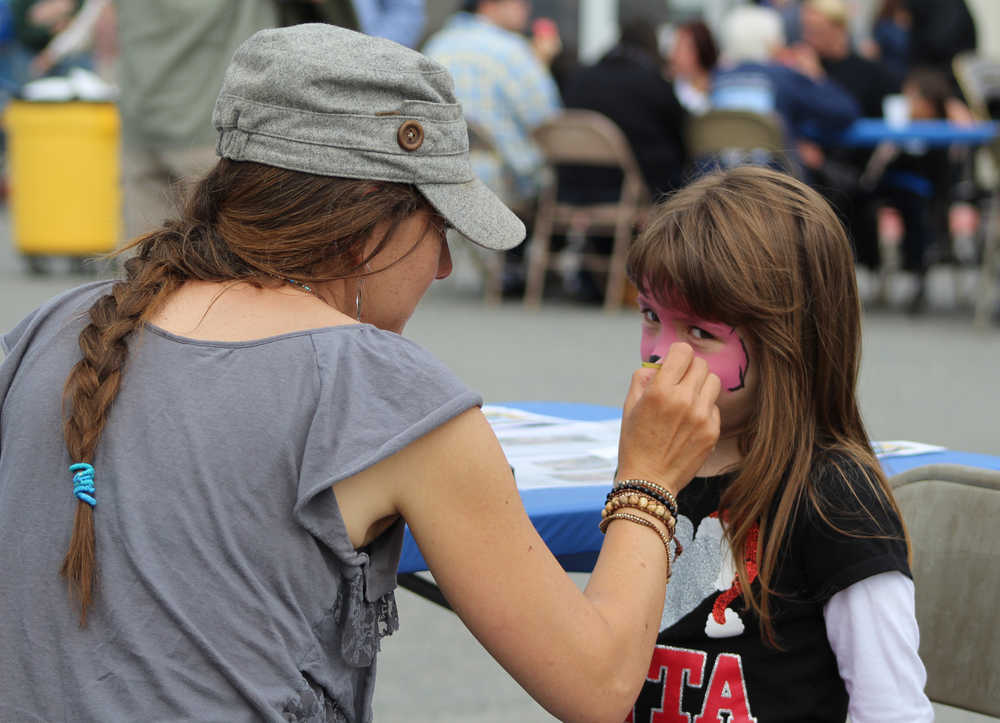 Brandi Scott paints four-year-old Erica Koch's face during the South Peninsula Hospital 60th Anniversary Party on Saturday, July 9.