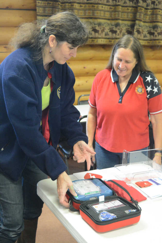 Samantha Cunningham, left, shows Bobby News how to work an automatic external defibrilator at the Anchor Point Senior Center. Cunningham is the Kenai Peninsula Borough Emergency Medical Services coordinator and Ness is president of the senior center board. Cunningham helped get a $43,000 grant from the Tesoro Foundation to install AEDs in public places on the peninsula, including Anchor Point.-Photo by Michael Armstrong, Homer News