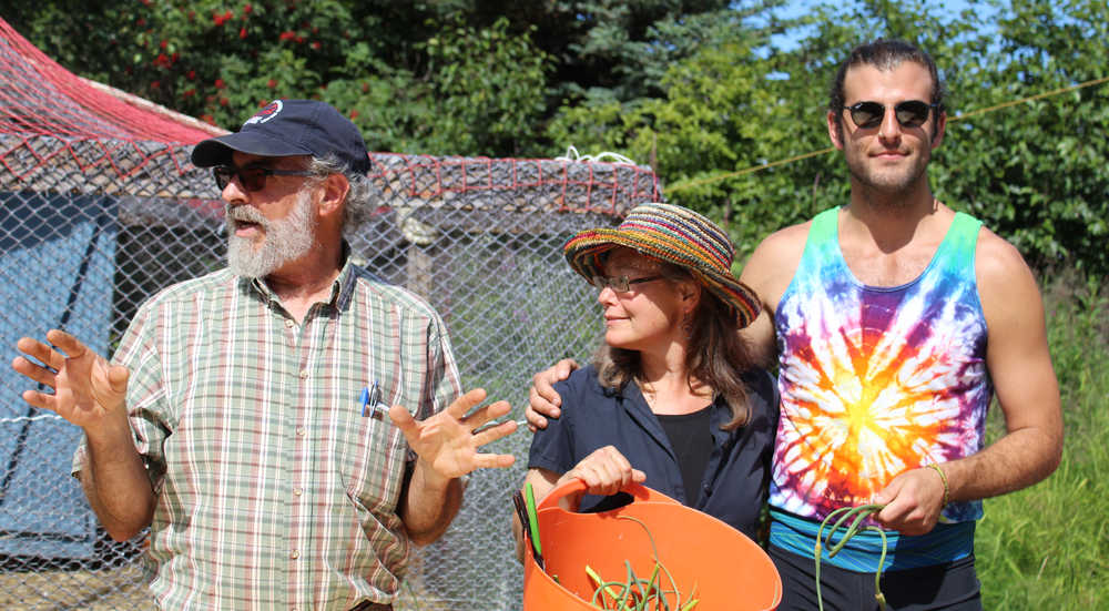 Wayne Jenkins, along with Lori Jenkins and Alex Folio, explains the activities available to guests in the afternoon at Synergy Gardens' First Annual Great Garlic Scape Festival. Folio lead a group in a yoga flow, while Wayne guided a farm tour, and others took part in making botanical art.