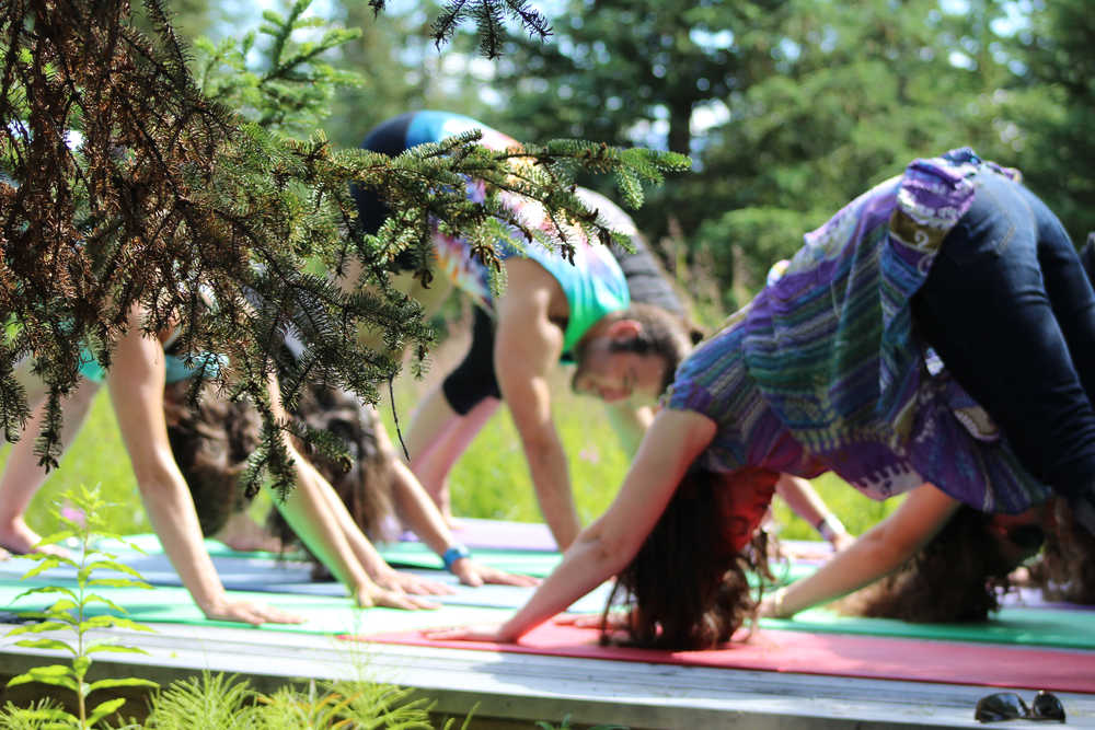 Many Rivers yoga instructor Alex Folio leads a group in a yoga flow on a platform at Synergy Gardens during the First Annual Great Garlic Scape Festival.