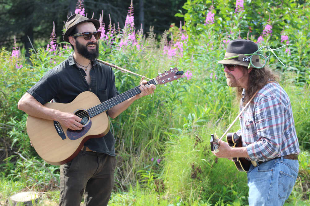 (left to right) Max Doyle and Kenute Tonga sing and play their guitars, providing live music throughout Synergy Gardens' First Annual Great Garlic Scape Festival.