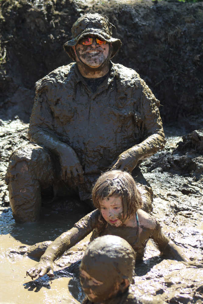 Kevin Wilmet and his daughter Dee Wilmet bask in the mud pit at the 2016 Mud Wallow at Cottonwood Park on July 17.