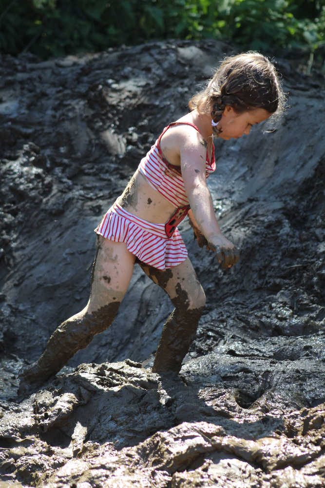 Sophie Williams treks through the mud to get to the side of the pit at the 2016 Mud Wallow on July 17.