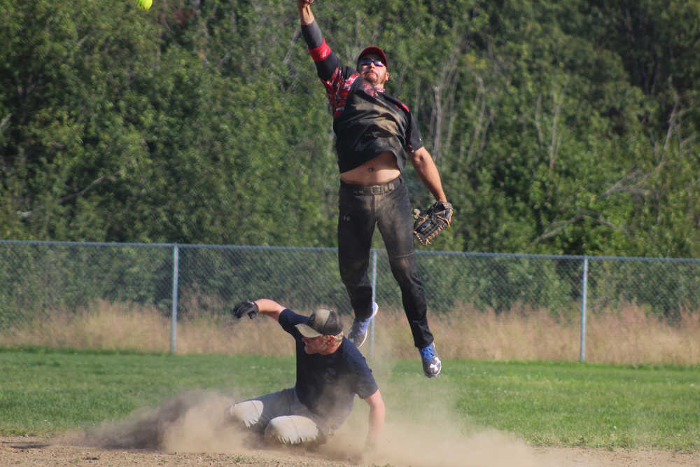 Mean Machine shortstop Danny Stanislaw leaps to catch the ball as he tries to get Beluga Lake Lodge player and coach Philip Jones out at second during the second game in the Homer city league tournament on Sunday, July 31.