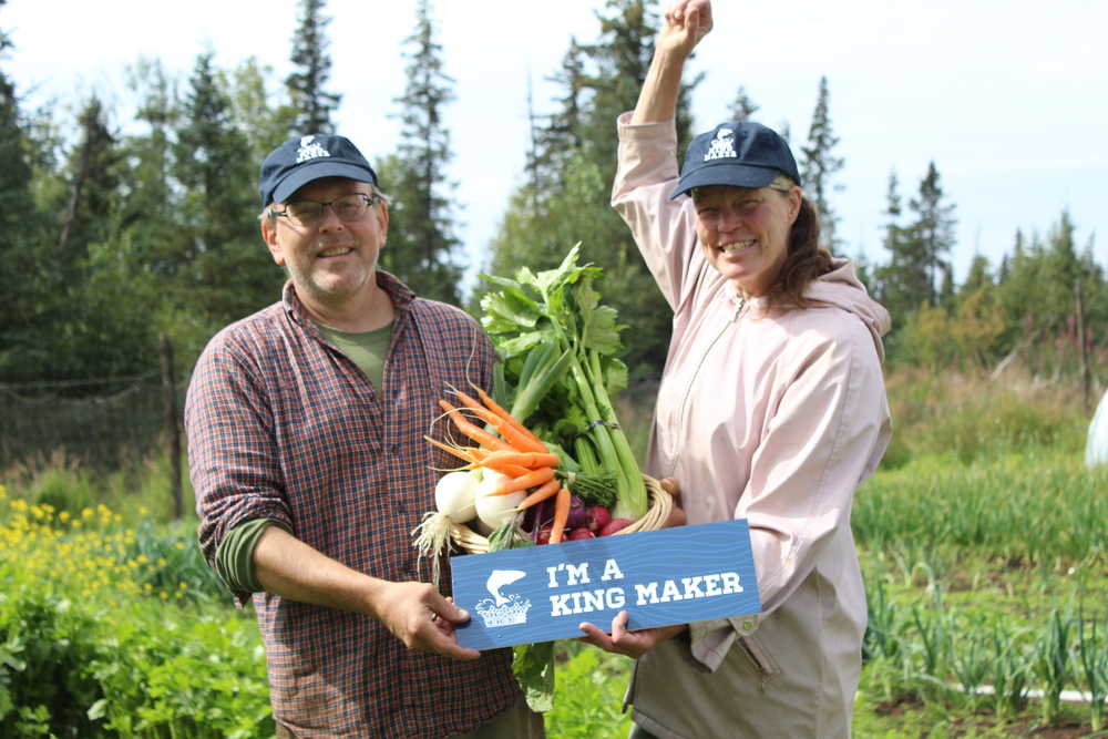 Paul and Jen Castellani of Will Grow Farm stand in their large garden plot with a cornucopia of their fresh vegetables and cheer as they are declared Kachemak Heritage Land Trust's second King Maker. The King Maker award celebrates individuals who do their part to help keep salmon habitats safe.