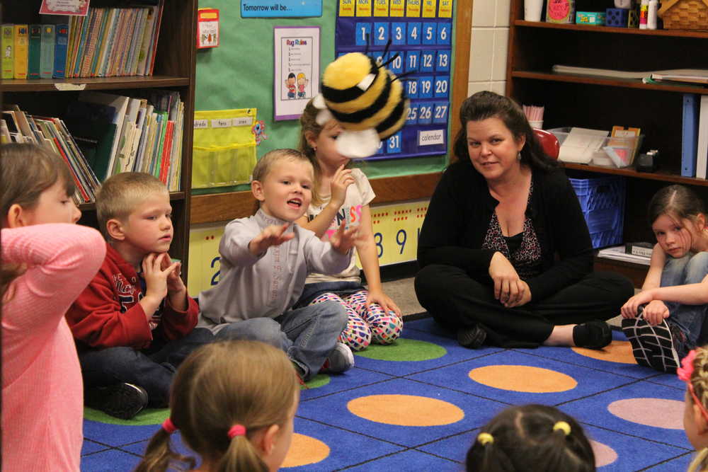 8:30 a.m.: After reading, Anne Love leads the kids in a name game in which the person holding a stuffed bumble bee says their name and then the class says the name back three times: first outloud, then as a whisper, and then spelled out while clapping. Love also went over more classroom and school rules with the class, framing the exercise by telling the class she was new too and asking if they could tell her some of the rules they knew.
