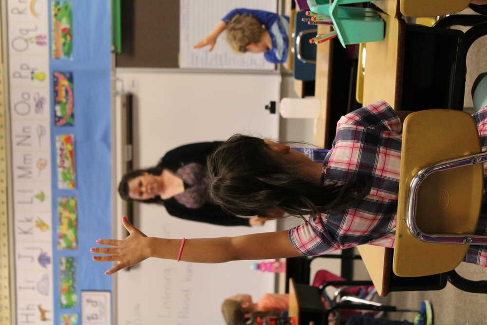 8:56 a.m.: Anne Love looks for a student to call on as the class does an exercise that helps the kids memorize facts about their class. While the students were at their desks, Love also talked about how to behave while they listen to her or other students talk.