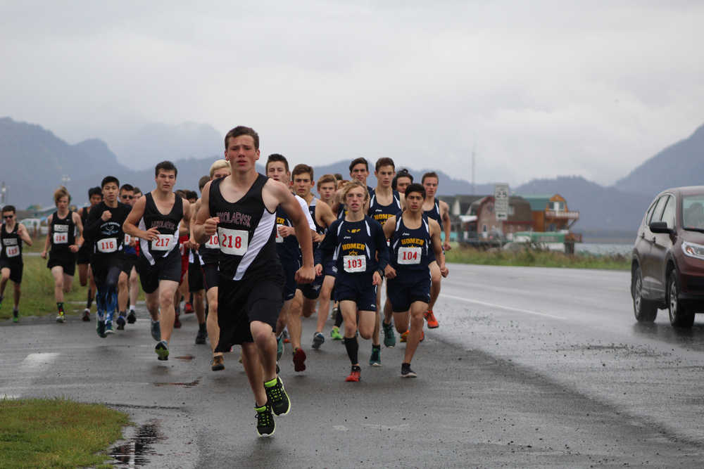 Boys cross-country runners from Homer, Nikolaevsk, Kenai, Voznesenka, Port Graham, Nikiski and Soldotna take off from Pier One Theatre to run five kilometers to the base of the Spit in the Homer Spit Trials on Saturday, Sept. 17. The weather stayed gray all morning, forcing the boys and girls teams to run in the rain.