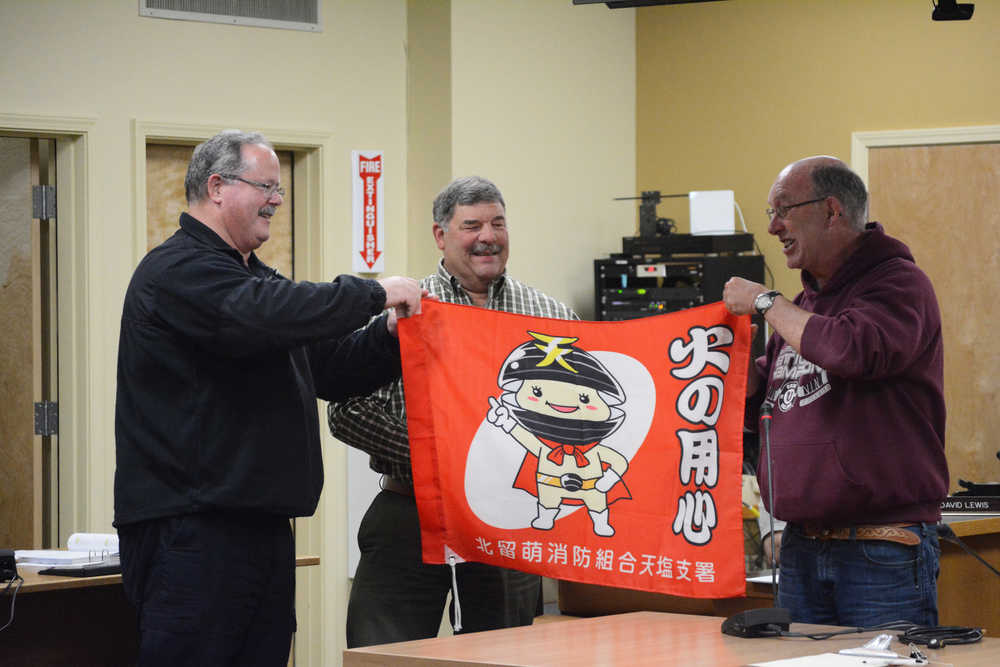 Homer City Council member and mayor pro tempore David Lewis, right, presents a fire-wise flag from Teshio, Japan, to Homer Volunteer Fire Department Chief Robert Painter, left, as Homer Police Chief Mark Robl, center, watches. Lewis recently returned from a trip to Japan where he visited Homer's sister city, Teshio. Lewis also gave Robl a Teshio police pin. "Our sister city really outdoes itself when you are there," Lewis said. "I have never been treated so well in my whole life."