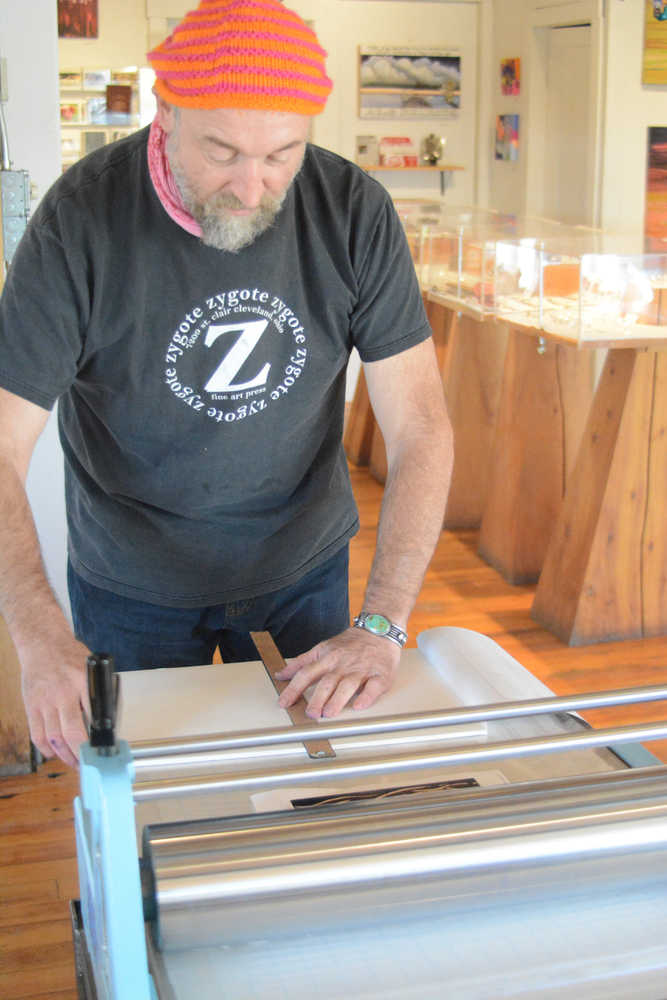 Claudio Orso-Giacone prepares a wood block to make a print during his residency at Bunnell Street Arts Center last month. The printing press was donated to Bunnell by the estate of Homer artist Gaye Wolfe.