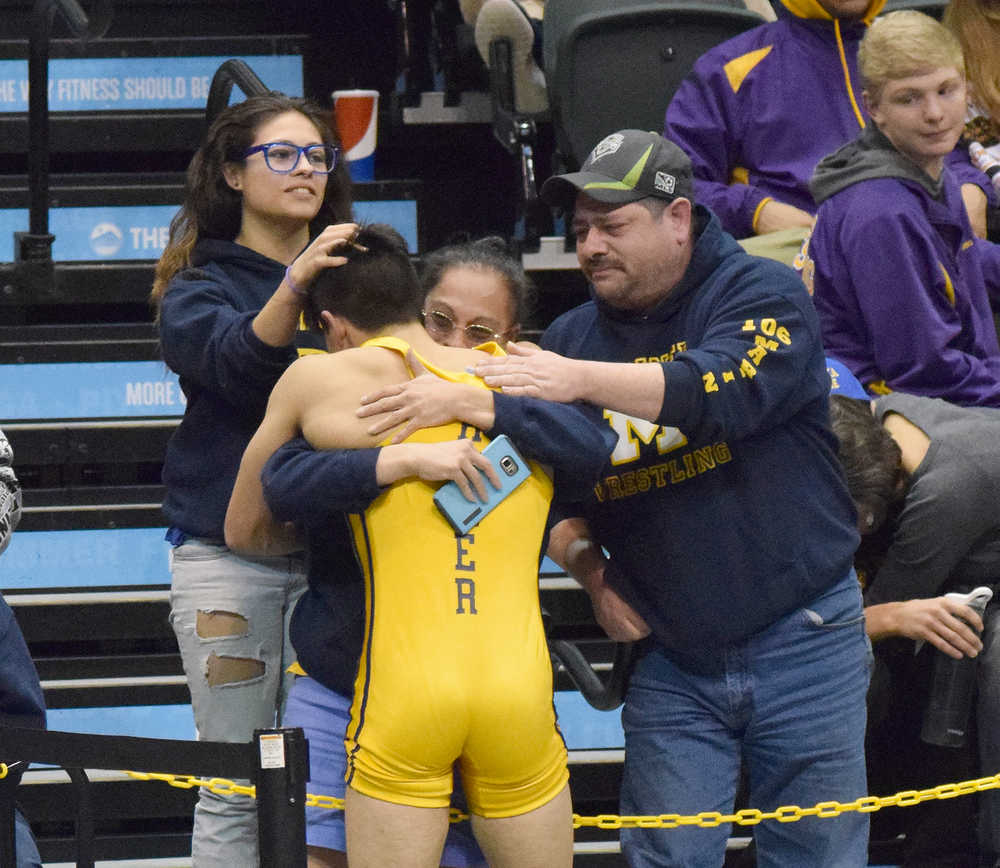 Photo by Joey Klecka/Peninsula Clarion Homer sophomore Luciano Fasulo receives hugs from his family Saturday night at the Class 1-2-3A state wrestling tournament at the Alaska Airlines Center in Anchorage.
