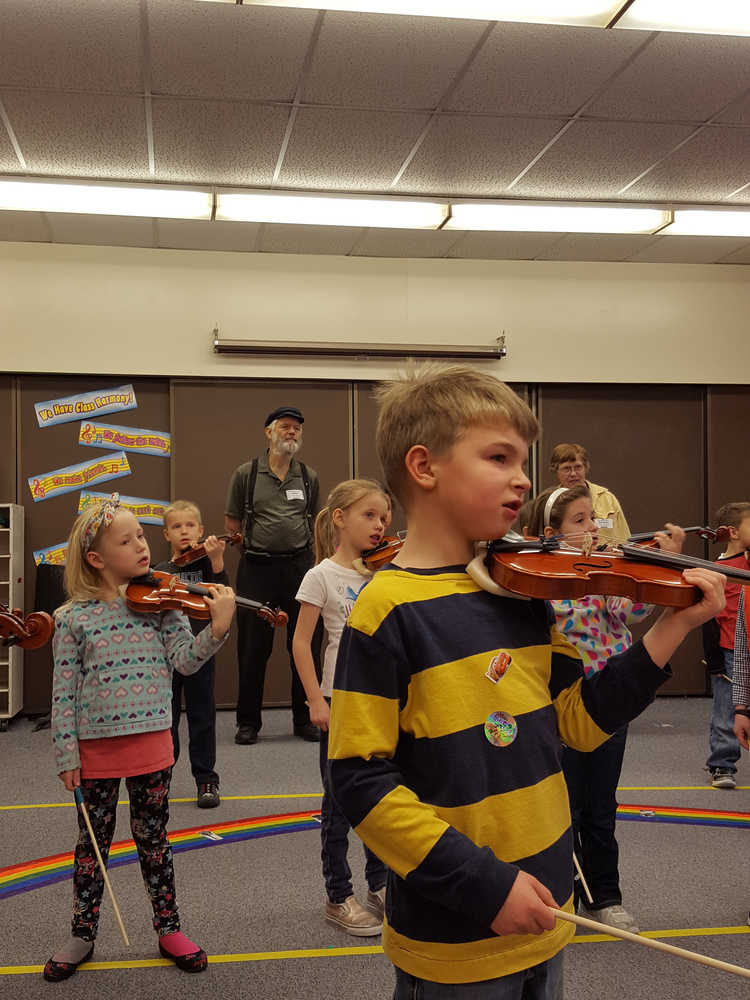 Violinists Gabe Stanislaw, Isabella Arno, Tatum Kirtly, Sawyer Shelby practice during class as Rep. Paul Seaton and Linda Reinhart look on.