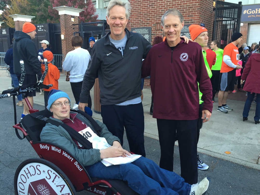 Larsen Klingel reclines in his racing wheelchair and poses for a photo with friends (left to right) Scott and Andy Beardsley. Andy pushed Klingel in the racing wheelchair in the Richmond Marathon in Virginia, qualifying for the 50-and-older category in the Boston Marathon.