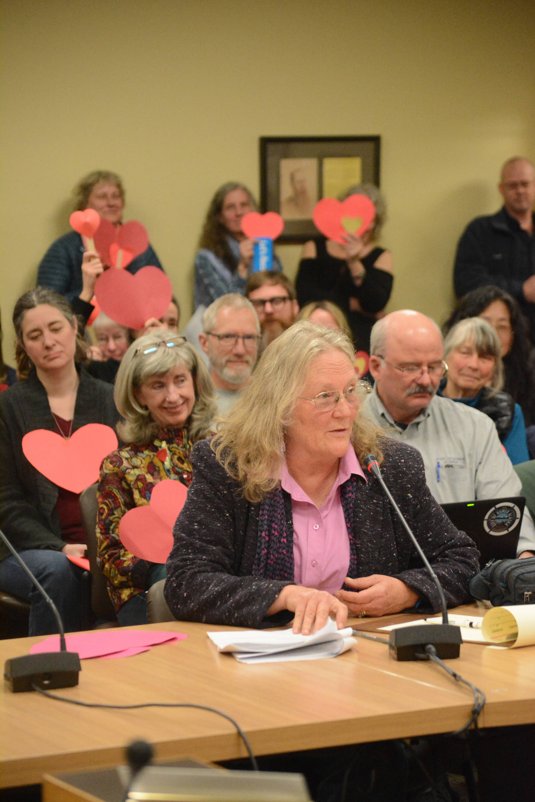 At the Homer City Council meeting on March 28, Poppy Benson speaks in support of council members Donna Aderhold, David Lewis and Catriona Reynolds, the targets of a movement to recall them. Many of the 100 people attending Tuesday's meeting held paper hearts to show support for the three council members. One woman held a sign that said, "Let's recall hatred." Recall organizers have targeted the three because they sponsored Resolution 17-019, the inclusivity resolution. "I would hate to think any faction in our city would go after you," Benson said to Aderhold, Lewis and Reynolds. "It is very unfortunate the city is going to be put through this. I would like to express my support for all three of you who are the target of a vicious action." Tess Dally also spoke in support of the three council members as well as the council and the mayor.  "Three of you have made a difficult decision that really ended up taking a risk, taking a risk for people on the margin," Dally said of Aderhold, Lewis and