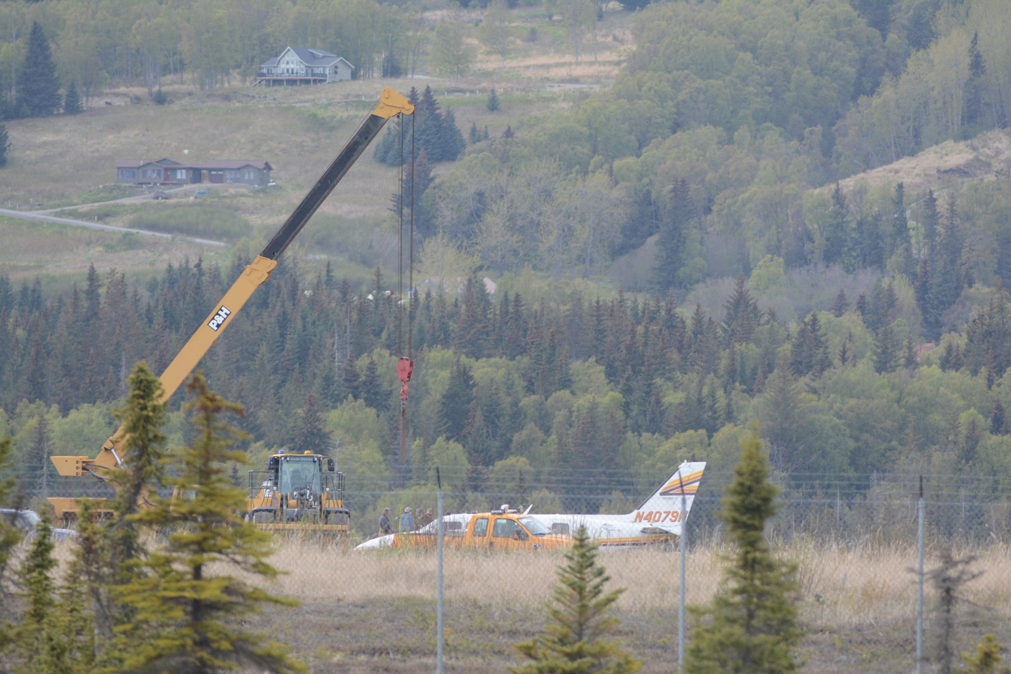 A crane operator moves into position to lift up an Alaska Air Transit Piper 31-350 Navajo-Chieftain off the Homer Airport runway last Saturday evening. The plane landed gear up about 4:10 p.m. May 16. No one was injured in the incident.-Photo by Michael Armstrong, Homer News