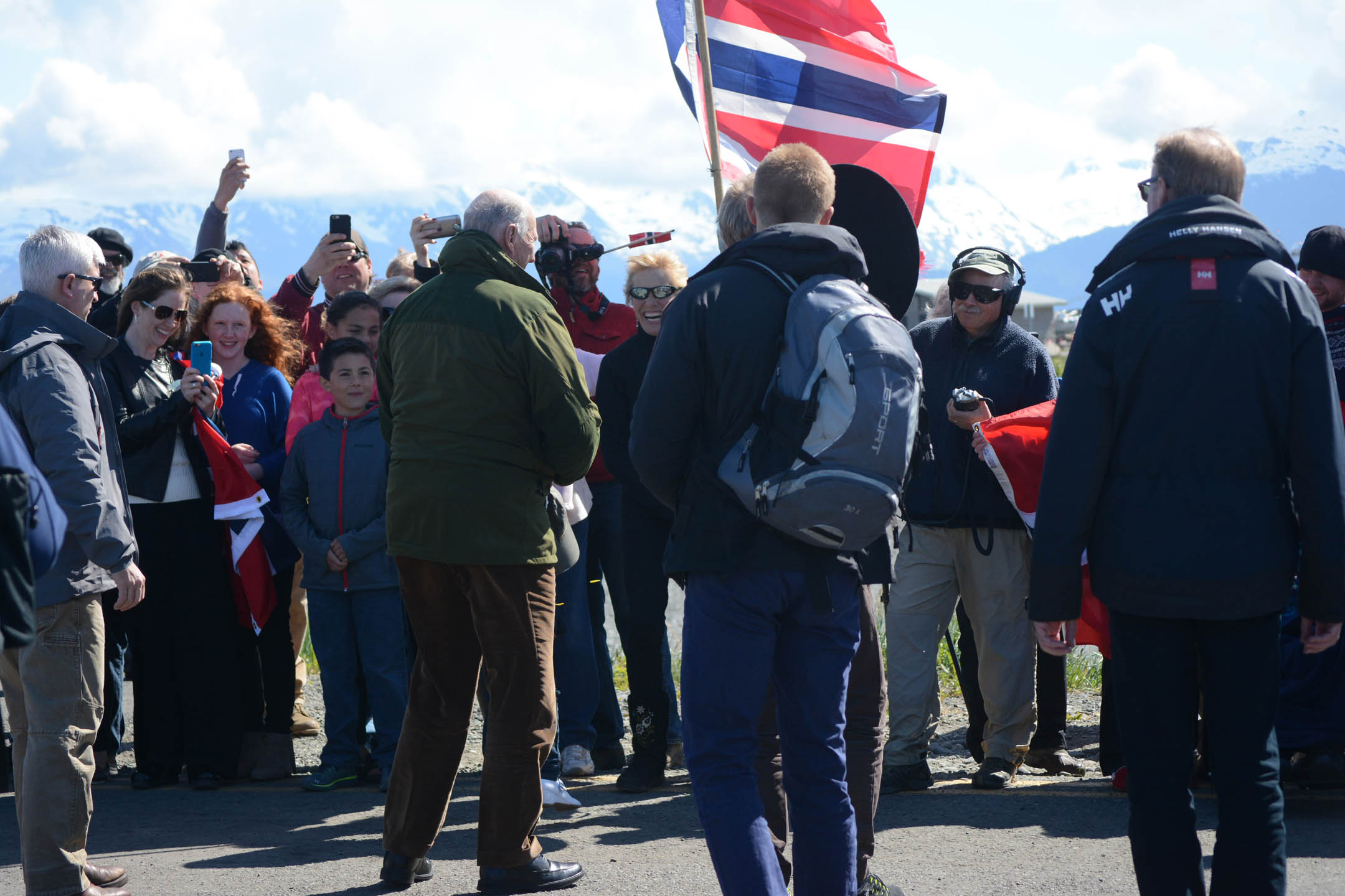 King Harald V, center, in the green jacket greets people as he arrives at the Homer Harbor on Tuesday.-Photo by Michael Armstrong; Homer News