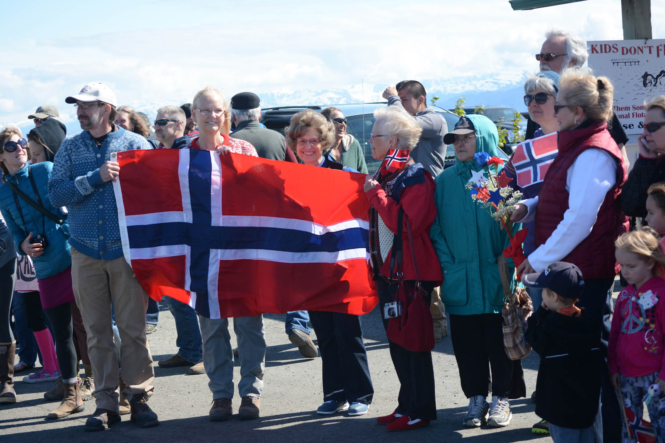 Wearing Norwegian sweaters and waving Norwegian flags, people prepare to greet King Harald V on his arrival Tuesday in Homer. It was the first official visit to Homer of a Norwegian king.-Photo by Michael Armstrong; Homer News