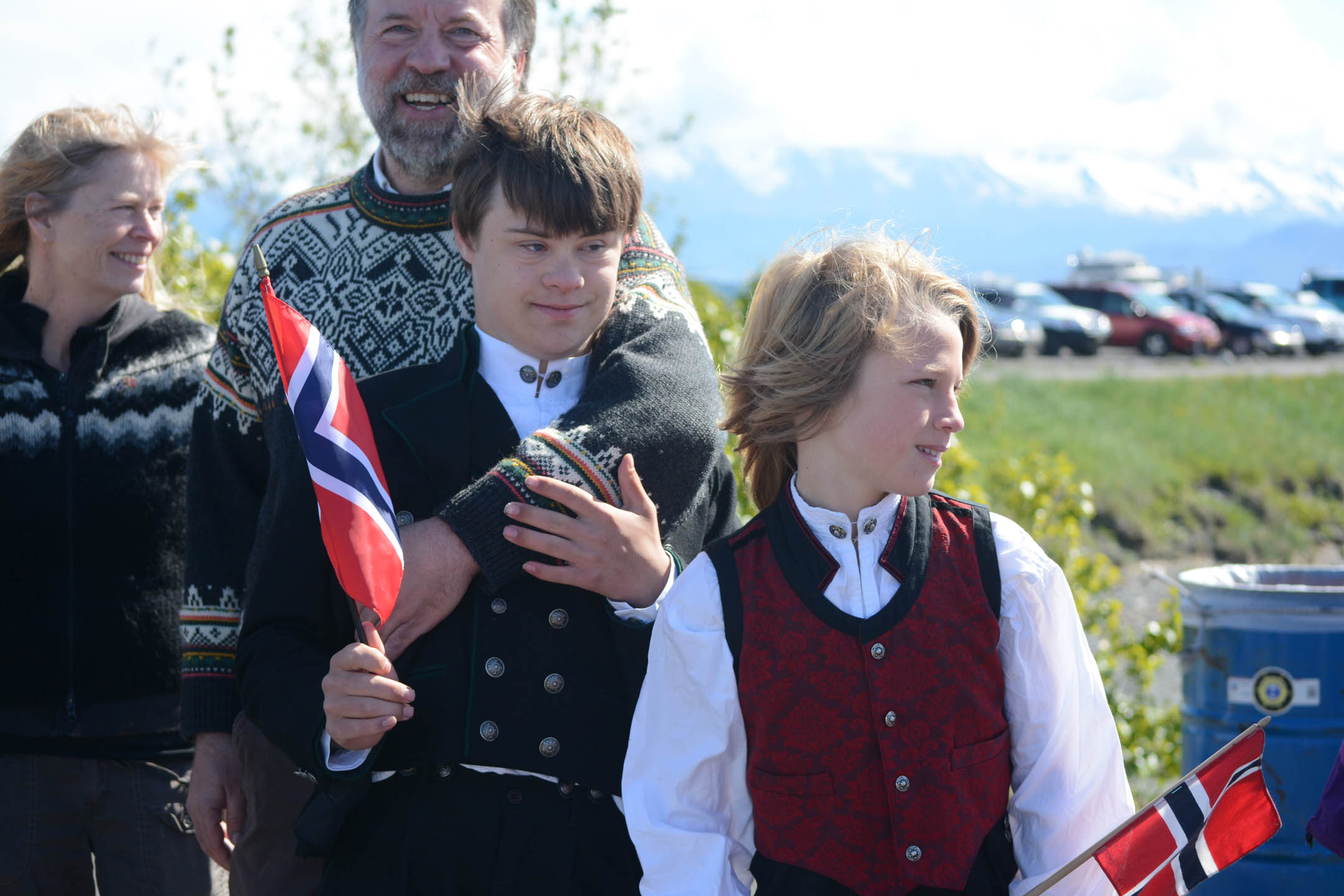 Mark Restad, back, stands with his sons Espen, left, and Leif, right, as they wait to greet King Harald V at the Homer Harbor on Tuesday morning. The boys wear traditional Norwegian "bunad" clothing.-Photo by Michael Armstrong; Homer News