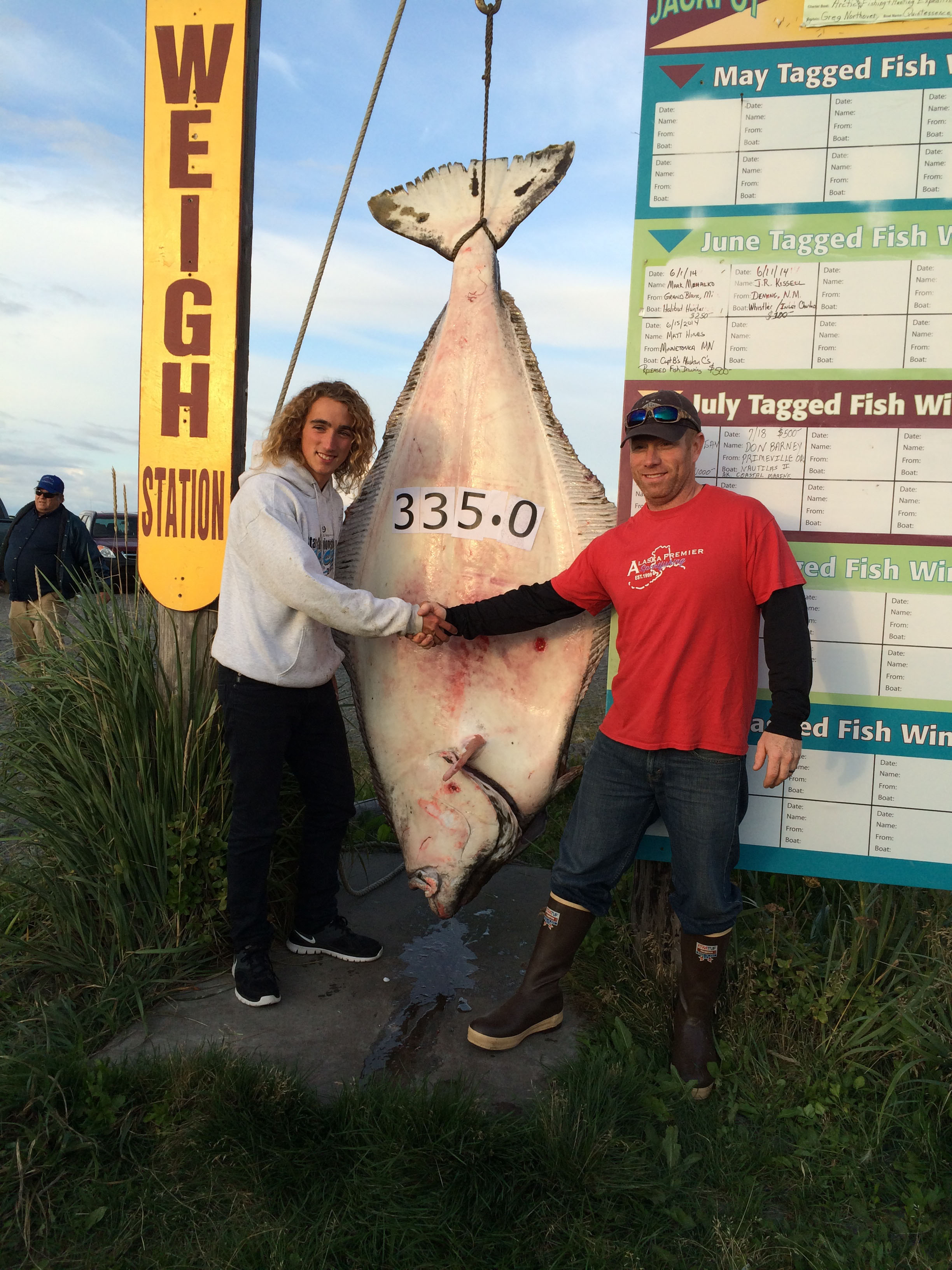 Jackson Hobbs, 16, of Franklin, Idaho, is congratulated by Capt. Travis Larson of Alaska Premier Sportfishing for the 335.0-pound halibut Hobbs caught while fishing with Larson on on Aug. 19, 2014. Hobbs’ fish was worth $16,731.50 in last year’s jackpot halibut derby.-Photo Provided