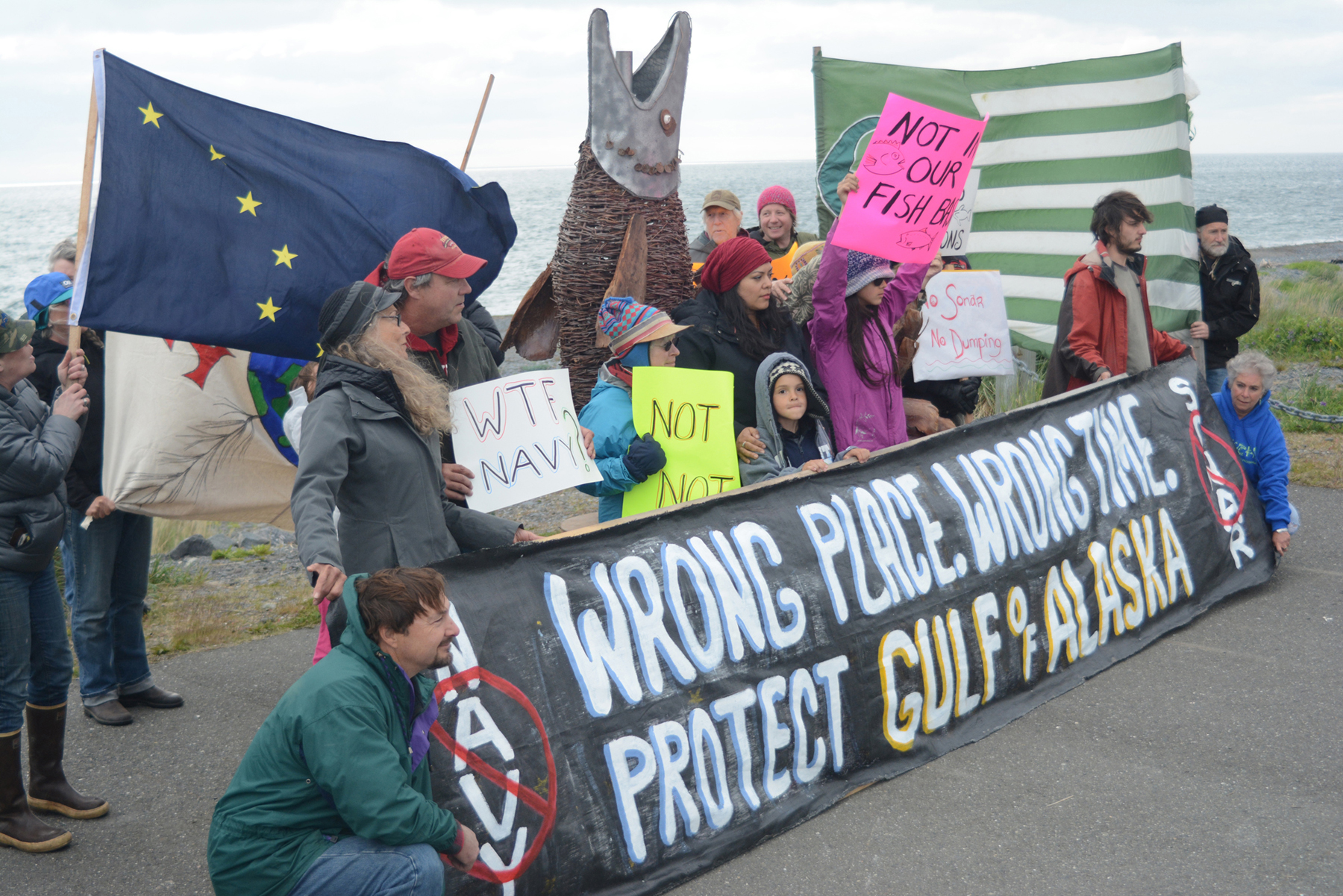 Protesters hold flags, sign and banners at a rally on Friday afternoon at the Seafarers Memorial on the Homer Spit. The protest was aimed at Northern Edge, a joint military exercise running June 15-26 in the Gulf of Alaska.-Photo by Michael Armstrong, Homer News