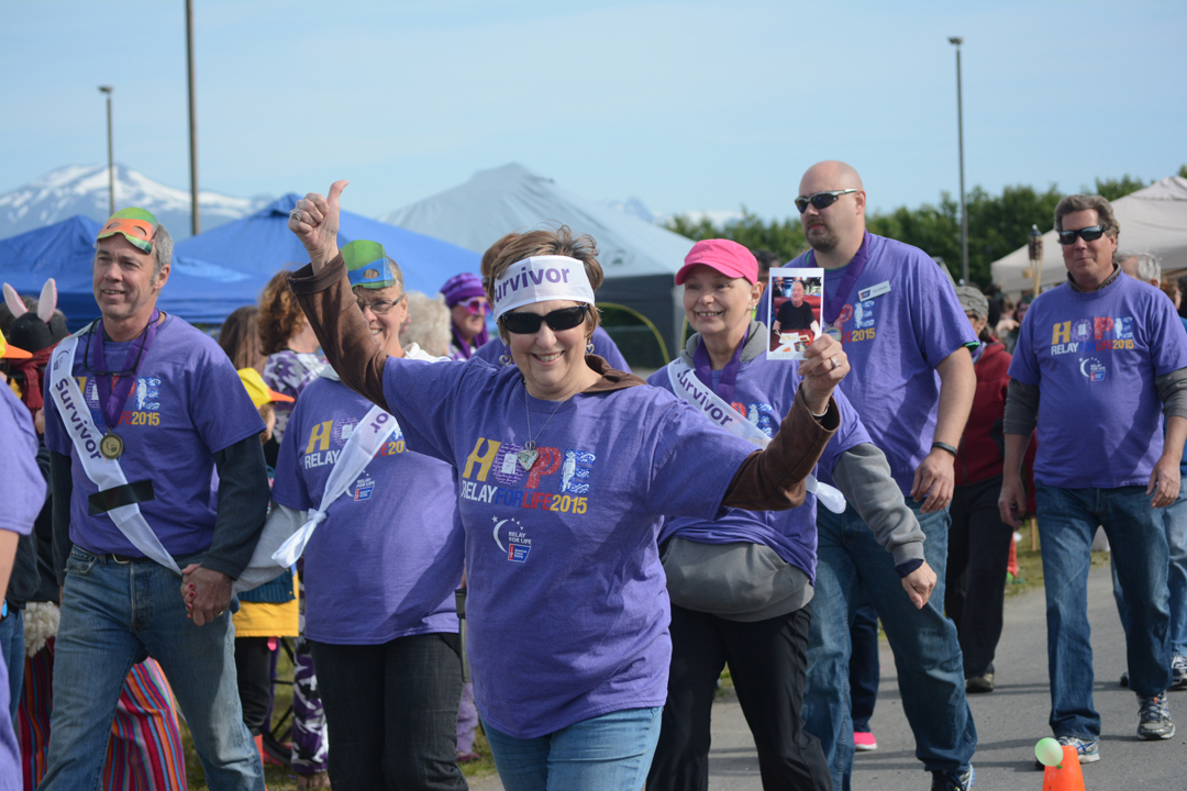Ginger VanWagoner cheers as she walks the survivors walk. She carries the photo of Michael Berlyn of Boynton Beach, Fla., declared cancer free last week.-Photo by Michael Armstrong, Homer News