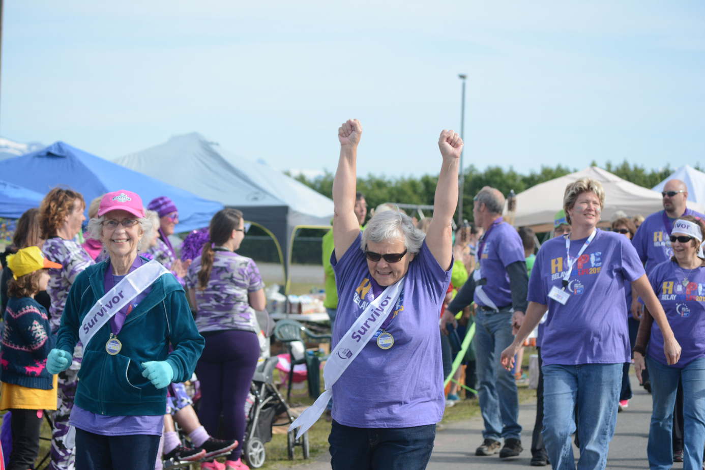 Diann Martin, center, cheers as she and Nancy Branch, left, take a lap during the survivors walk at Relay for Life last Friday at West Homer Elementary School.-Photo by Michael Armstrong, Homer News