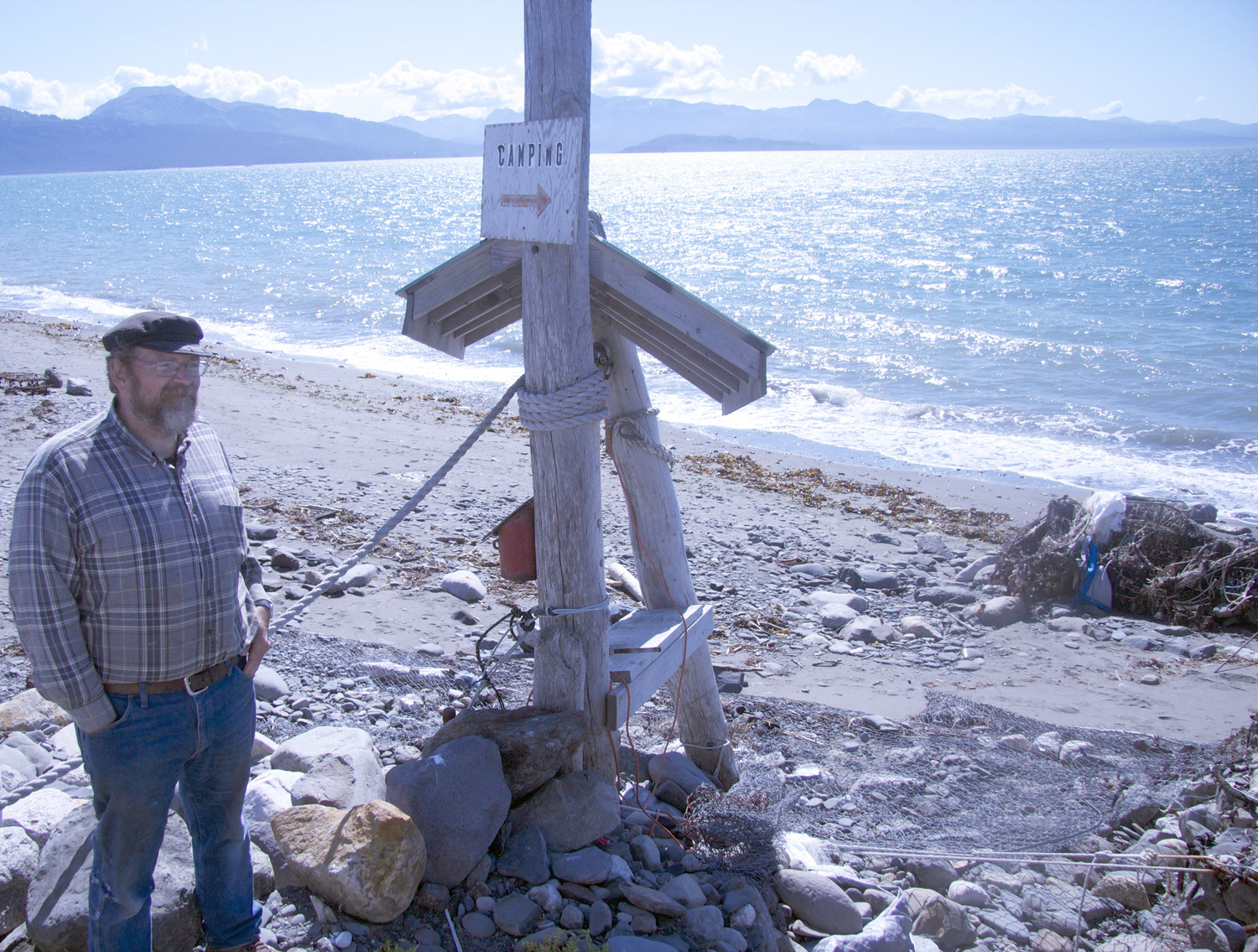 Dan Young stands on Spit property he and his wife Pam own. Located on the west side of the Spit across from the Fishing Hole, the property once was an RV campground. Today there’s little left of the campground; erosion has swept it away.-Photo by Miranda Weiss