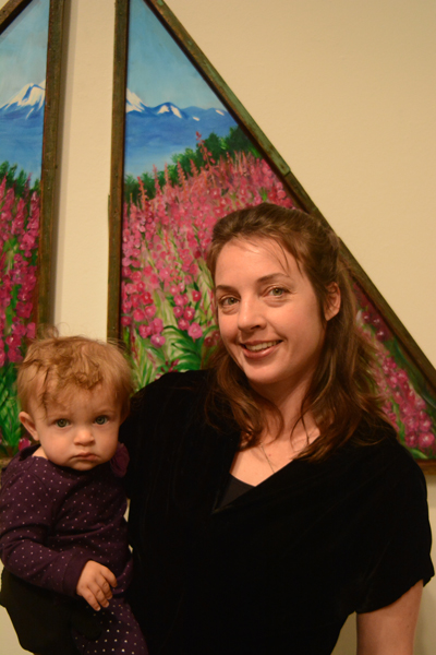 Julie Tomich holds her daughter, Xelia, at her show’s First Friday opening.