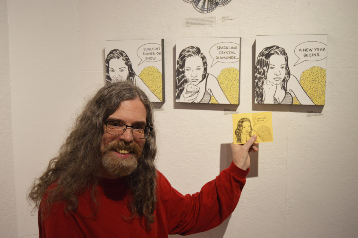 Artist Brian Payne poses with his tryptich at Bunnell Street Art Center’s 10x10 show opening on Nov. 20. The piece was inspired by a comic strip he created that includes a haiku written by his wife, Skywalker Payne.-Annie Rosenthal, Homer News