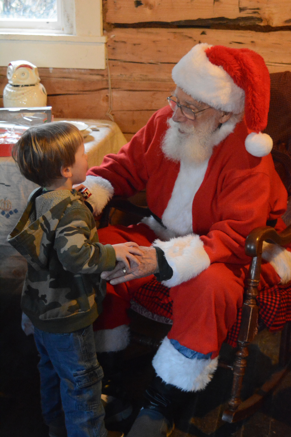 Santa Claus visits with Ryder Donahue at the Harrington Cabin during the Pratt Museum Stocking Stuffer Party last Saturday. Ryder is from Eagle River and was visiting his grandparents in Homer.