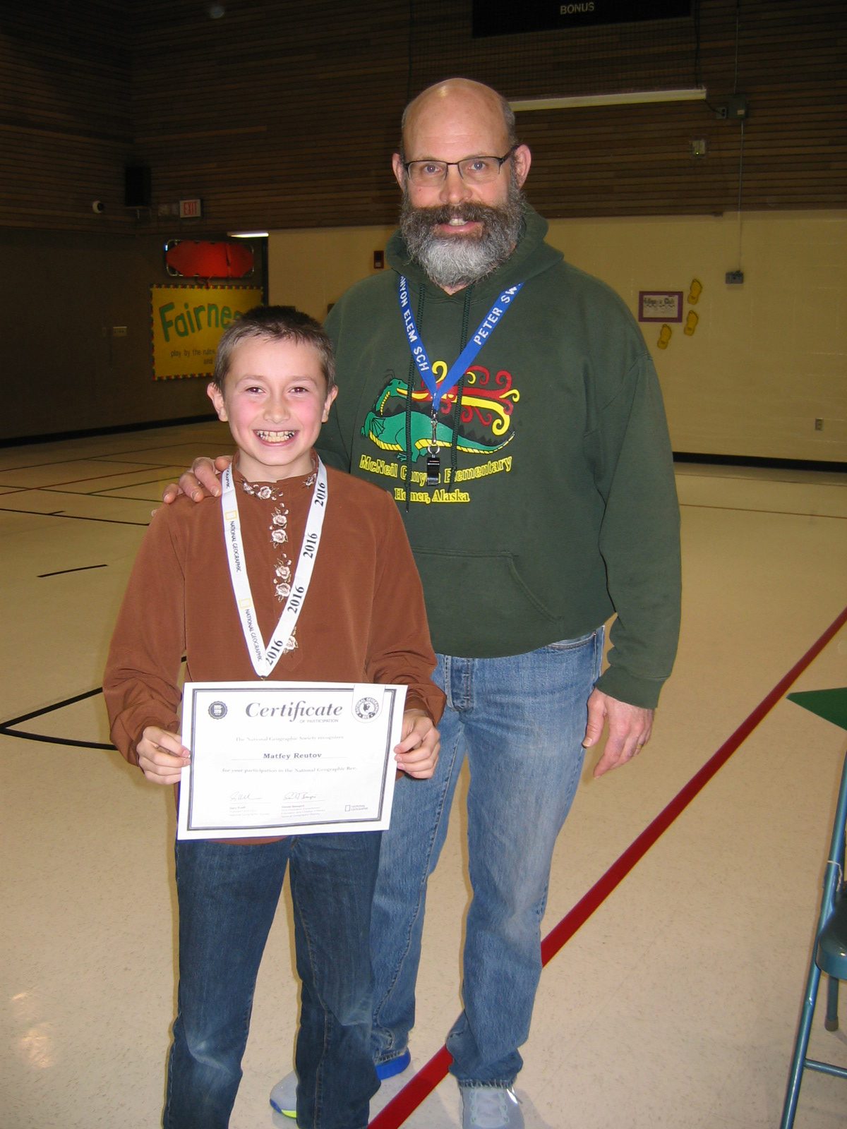Matfey Reutov shows off his certificate after winning McNeil Canyon Elementary School’s geography bee. Principal Pete Swanson, right, is there to congratulate Matfey.-Photo provided