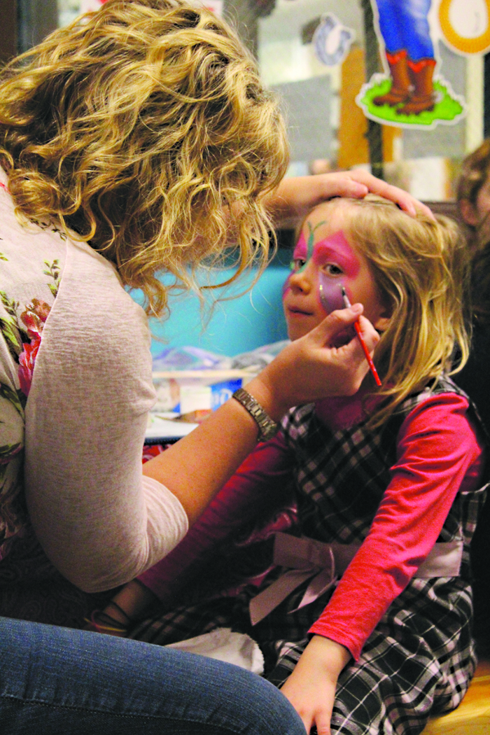 Joni Wise paints Paul Banks Elementary School second grader Xoe Bremicker’s face at the carnival last Saturday.-Photo by Anna Frost, Homer News