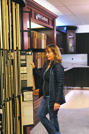 Customer Kathy Hemstreet flips through flooring samples in the Spenard Design Center during the grand opening. Hemstreet has been visiting the new center over the last few weeks looking for ideas for the remodel of her home.-Photo by Anna Frost, Homer News