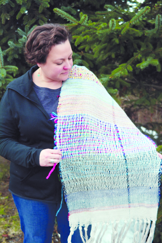 Pastor Lisa Talbott of Homer United Methodist Church holds a weaving made in a grief workshop. The flaw in the weaving was accidental, but was used by the weavers as part of the work.-Photo by Michael Armstrong. Homer News