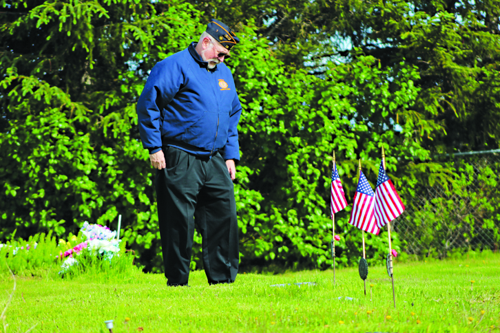 American Legion member Craig Forrest pays respect to veterans buried in Homer’s Hickerson Cemetery after the May 30 Memorial Day service.-Photo by Anna Frost, Homer News