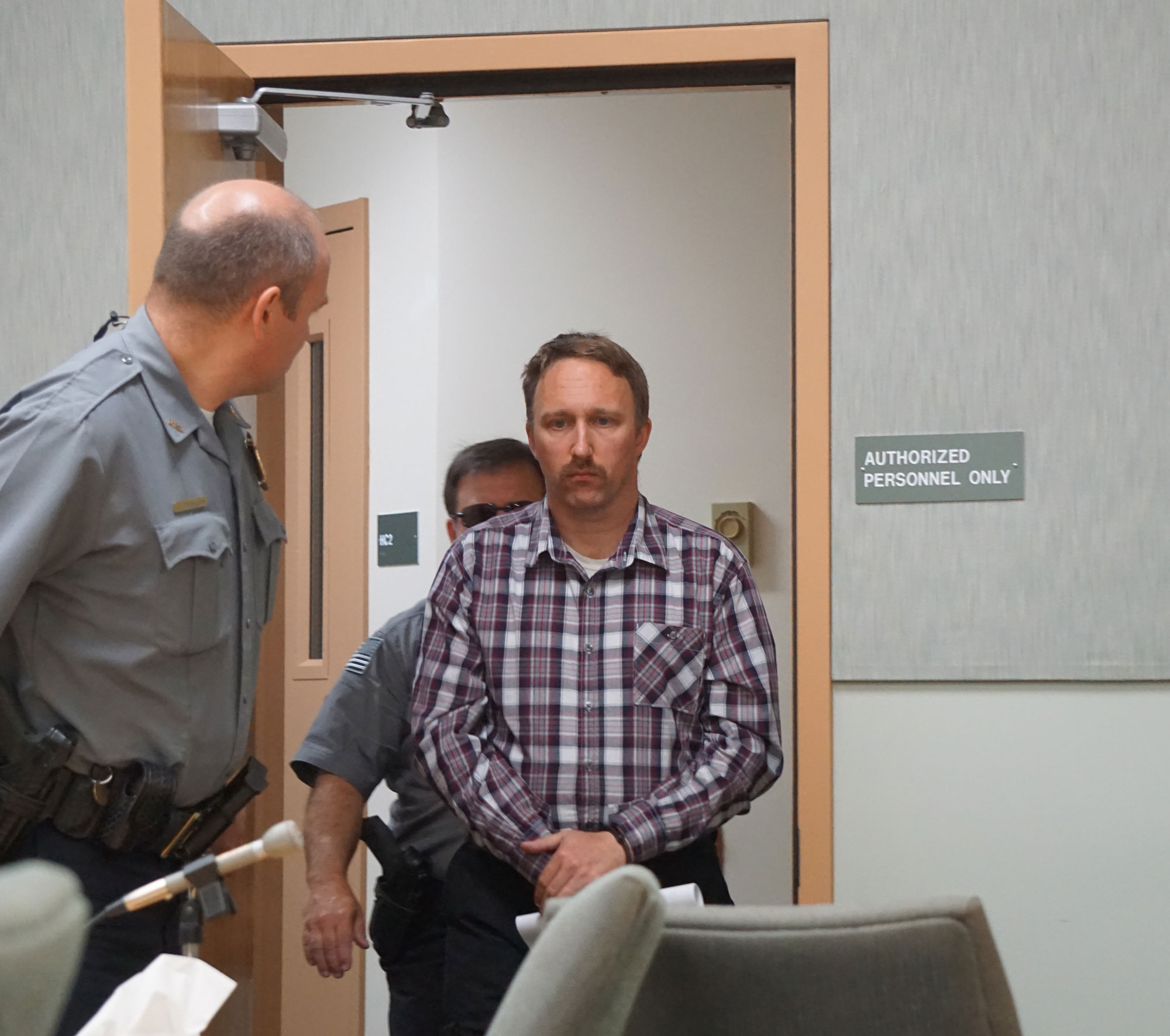 Judicial services and jail officers lead Stephen R. Boyle into the Homer Courthouse about 11 a.m. Friday. Boyle was arraigned on six counts of first-degree sexual abuse of a minor. He is the deputy chief for Kachemak Emergency Services.                             -Photo by Michael Armstrong, Homer News