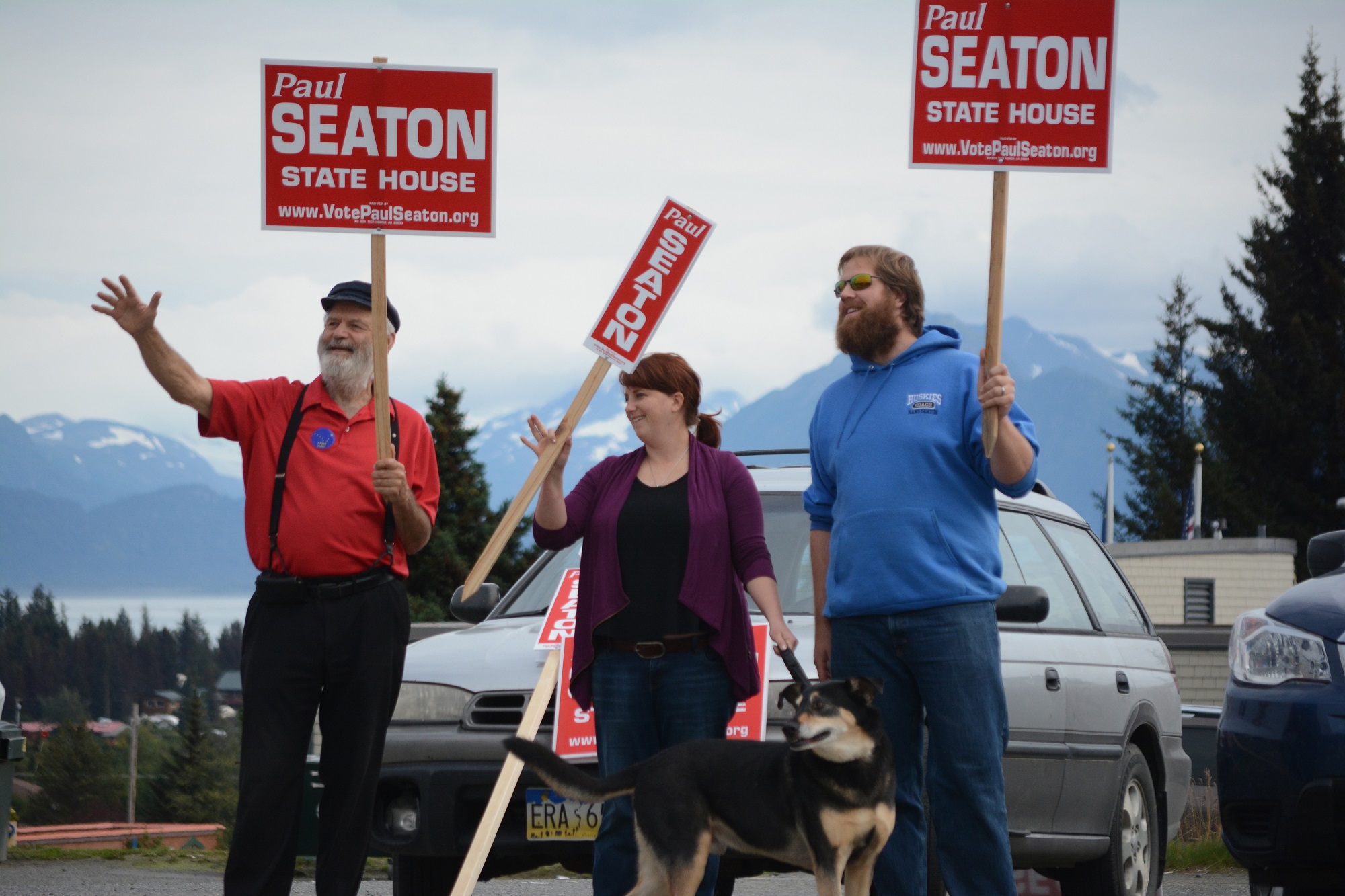 Rep. Paul Seaton, R-Homer, waves campaign signs at the corner of Lake Street and Pioneer Avenue on Tuesday. Joining him are his daughter-in-law, Lauren Seaton, center, and son Rand Seaton, right, and their dog, Bear.-Photo by Michael Armstrong, Homer News