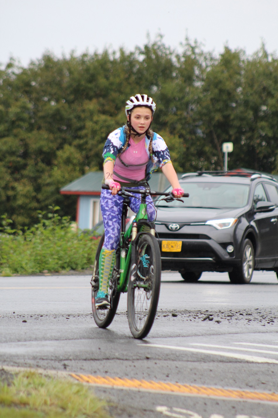 Ella Blanton-Yourkowski rides her bike across the intersection of Spit Road and Kachemak Drive. The triathlon had a person posted with a stop sign at intersections where competitors has to cross street to alert traffic to the presence of runners and bikers.