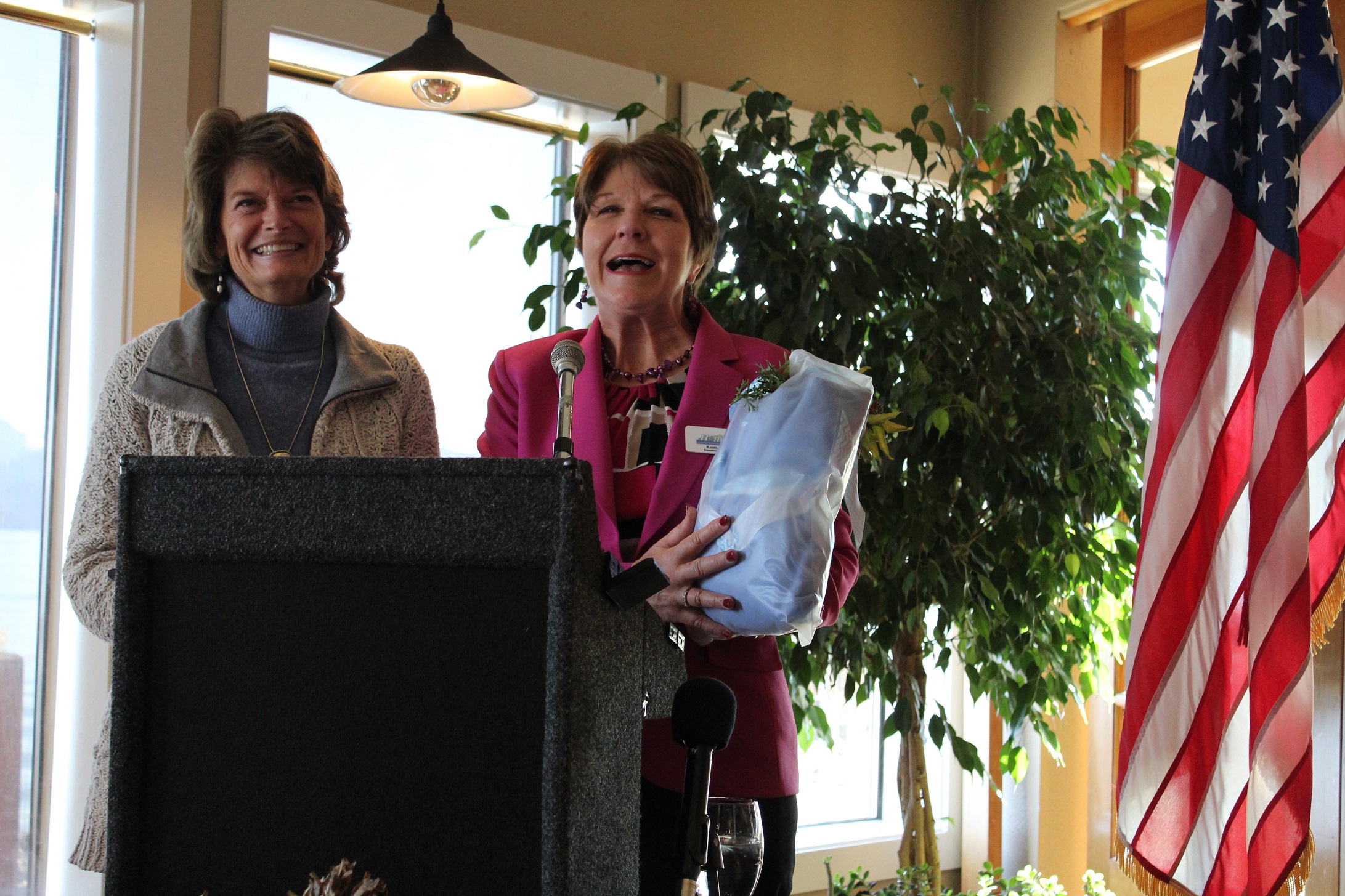 Homer Chamber of Commerce Executive Director Karen Zak presents Senator Lisa Murkowski with a Homer sweatshirt at Land's End Resort on Friday, adding that she hoped Murkowski might wear it in her next television commercial.-Photo by Anna Frost, Homer News