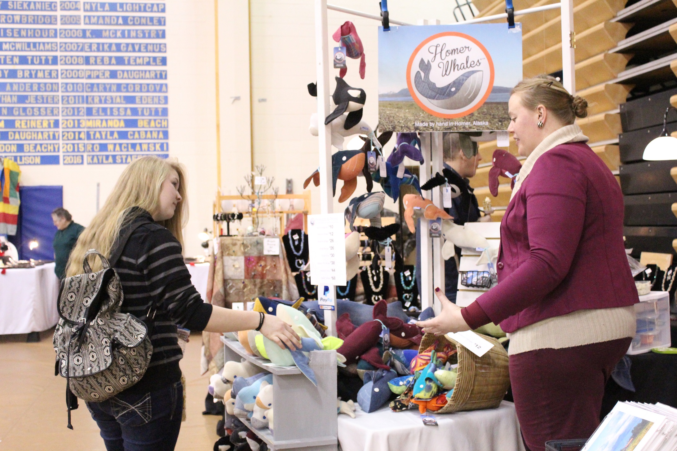 Abagail Kokai talks to a customer about her stuffed denim Homer Whales at the Nutcracker Faire on Saturday, Dec. 3.-Photo by Anna Frost, Homer News